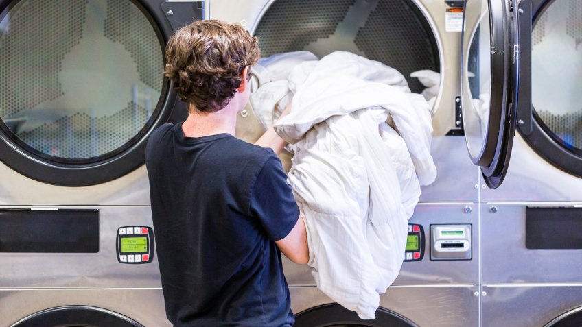 person doing laundry in laundromat