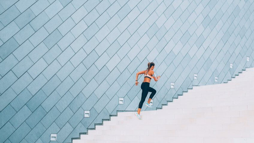 Woman exercising on a staircase outside in the city.