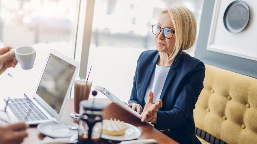 senior woman travel agent with client