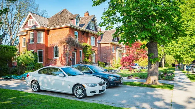Hamilton, Canada - May 22, 2016: Large houses, luxury cars and mature trees in the downtown historic neighbourhood of Dundas in Hamilton, Ontario, Canada.