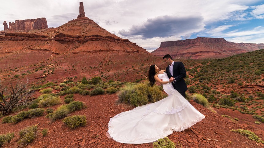 Asian/Vietnamese bride with groom posing in her wedding dress under Castleton Tower.