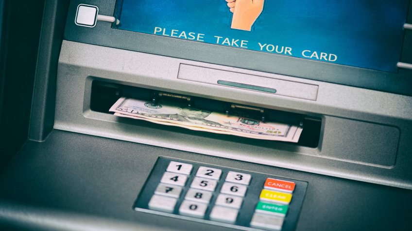 Close up view of dollar banknotes in ATM machine.