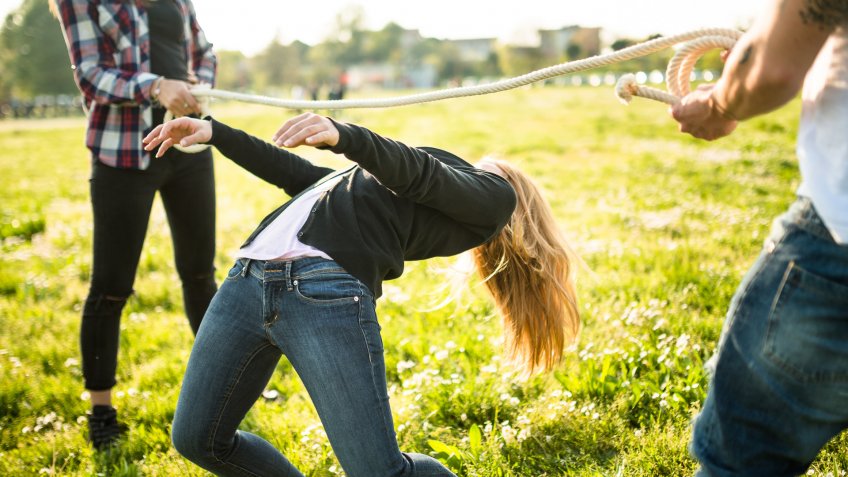 group of people playing limbo on the park.