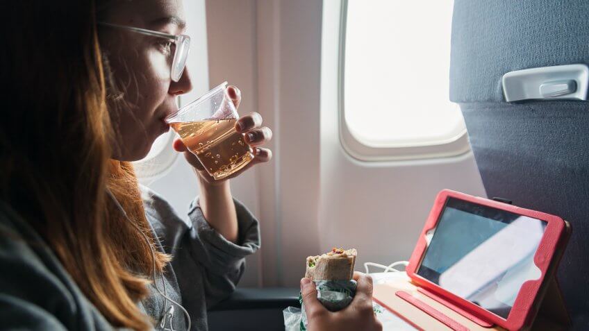 Millennial woman in comfy clothes travelling alone in plane.