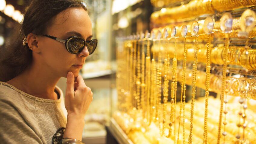 woman looking at gold jewelry
