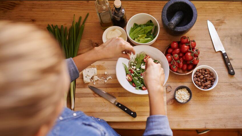 Cropped shot of an unrecognizable woman using ingredients to make a healthy salad.