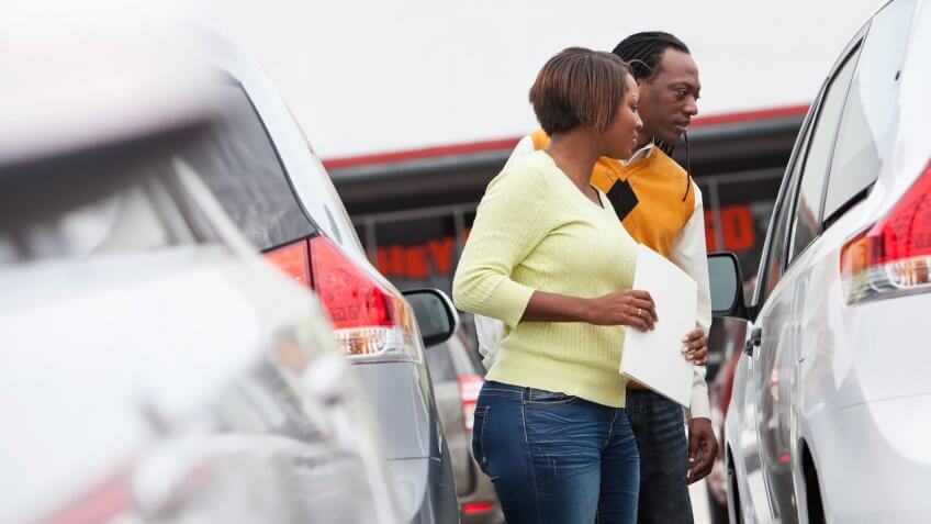 African American couple shopping for new car.