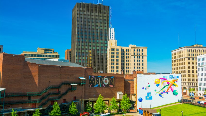 Akron, United States - May 29, 2014: Downtown Akron skyline with the words "Akron"on a sign in the center, and a colorful mural to the right.
