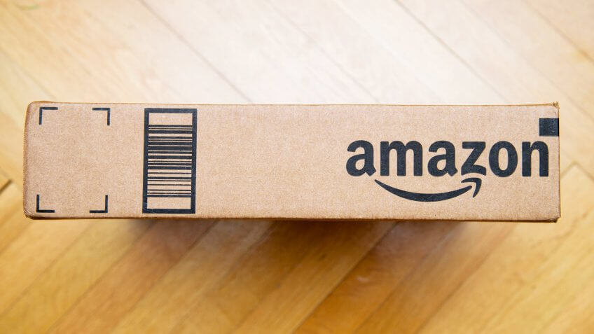 PARIS, FRANCE - JAN 28, 2016: Amazon logotype printed on cardboard box side seen from above on a wooden floor Amazon is the an American electronic e-commerce company - Image.