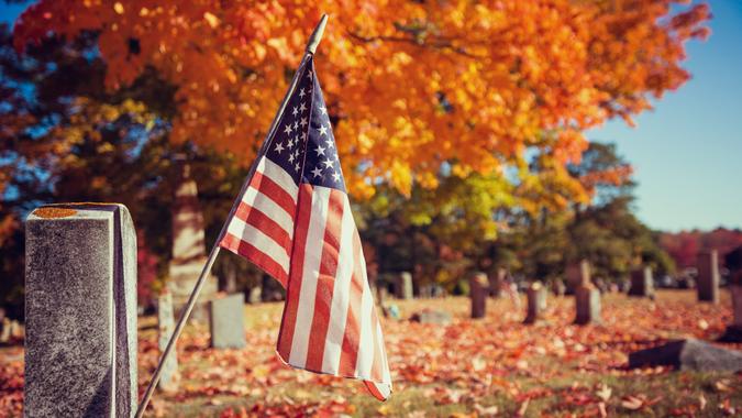 American veteran flag in autumn cemetery.