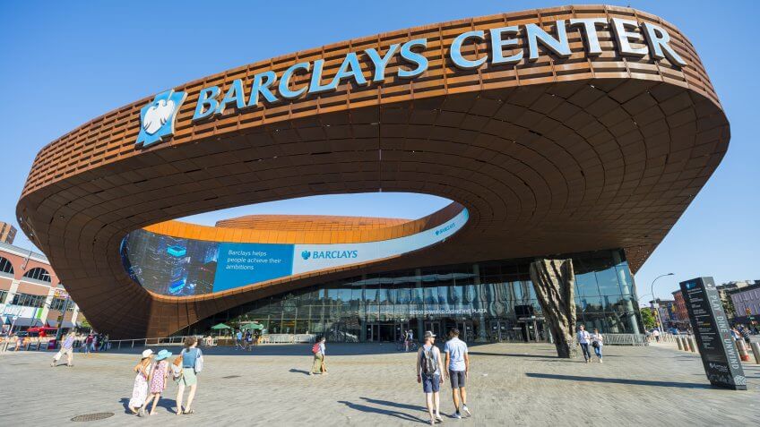 NEW YORK CITY - AUGUST 30, 2016: Pedestrians pass under the distinctive architecture of the Barclays Center, a recently constructed sports and entertainment complex in Brooklyn.