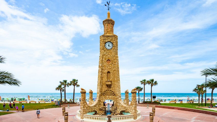 Daytona Beach, Florida, USA - May 21, 2017: The Daytona Beach Coquina Clock Tower on a sunny day with the Atlantic Ocean in the background.