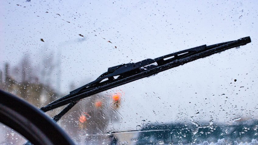 dirty car windshield with the included glass cleaner, in the big city front and back of the background is blurred.