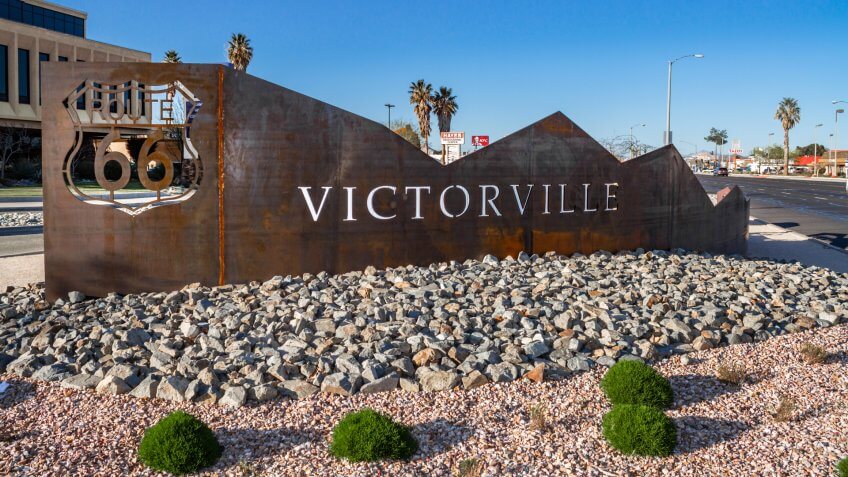 Victorville, CA / USA – March 30, 2019: Located on the corner of 7th St and Green Tree Blvd in the city of Victorville stands a rustic metal artwork featuring the Route 66 logo and the city name.