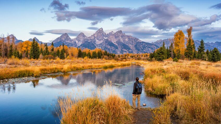 Stock photograph of hiker looking at view at Schwabacher Landing in Grand Teton National Park, Wyoming, USA, at dawn.