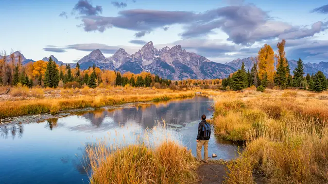 Stock photograph of hiker looking at view at Schwabacher Landing in Grand Teton National Park, Wyoming, USA, at dawn.