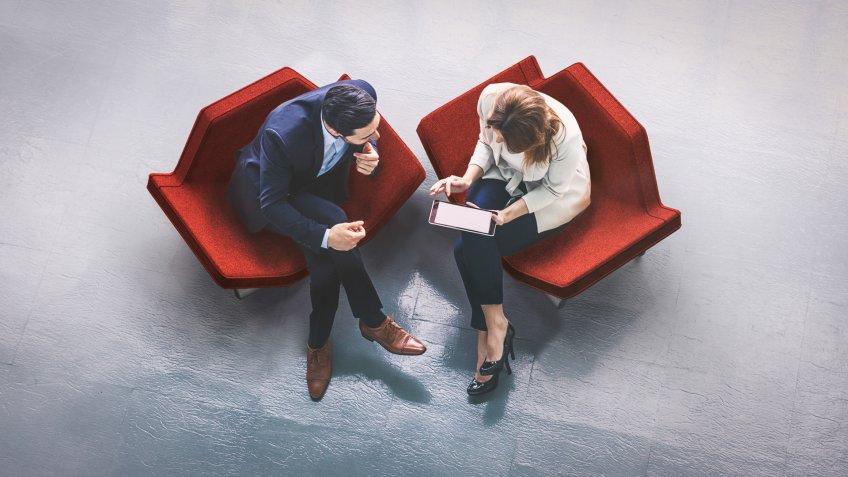 business colleagues talking in red chairs