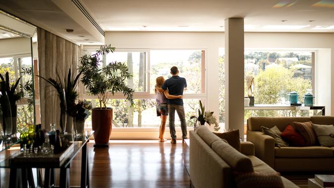 Couple admiring the view from the living room of their house.