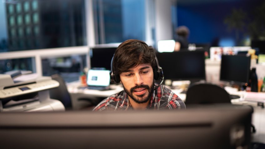 Employee working with headset in office callcenter.
