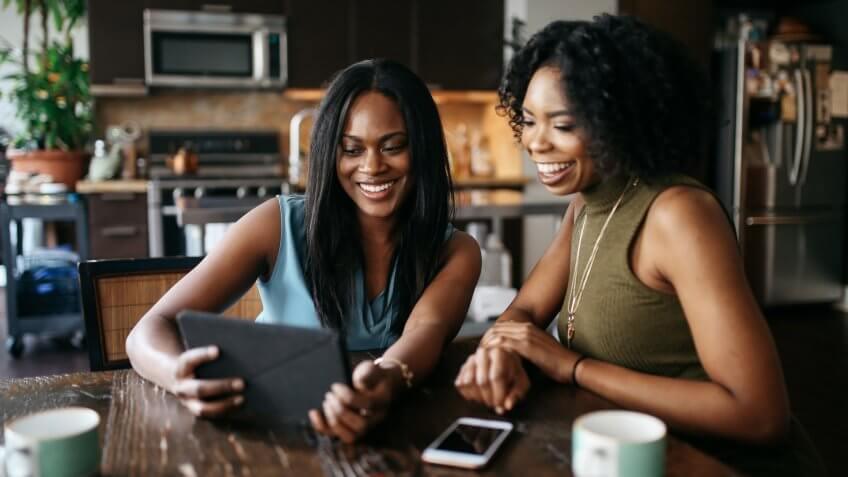 Two young mixed race Latina women spending the afternoon together, watching films or just browsing social media, having a relaxing day after work in their apartment in Downtown Los Angeles, California.