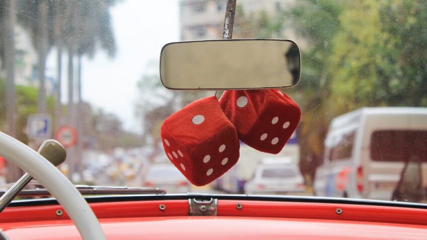Fuzzy red dice on a vintage red car in Havana.