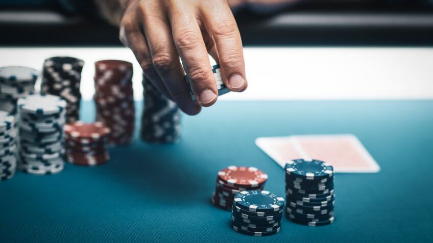 Successful player betting chips at casino and Hold 'em poker cards on the table, games and gambling concept.