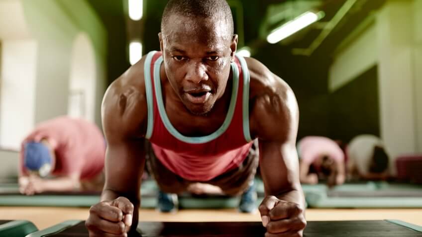 Shot of a man doing a plank exercise at the gym.