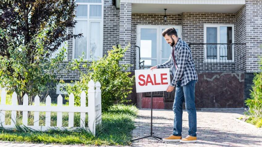 guy putting for sale sign