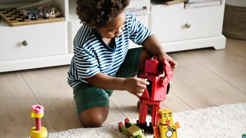 Black boy playing robot at home.