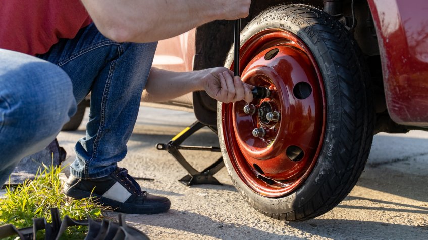 man changing tire to spare