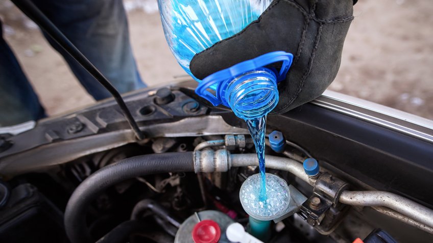 mechanic putting antifreeze in car