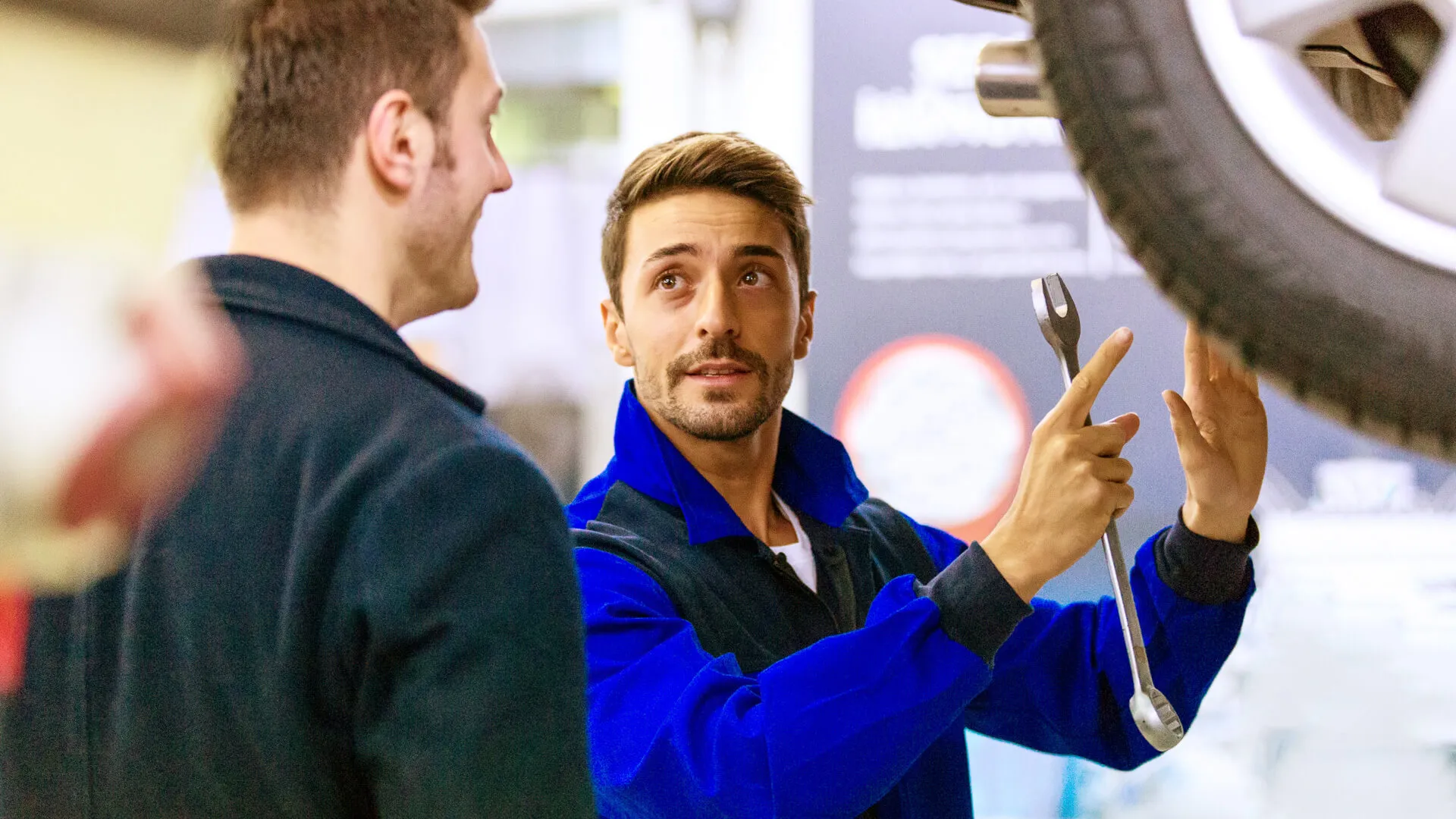 Auto mechanic talking with car owner.