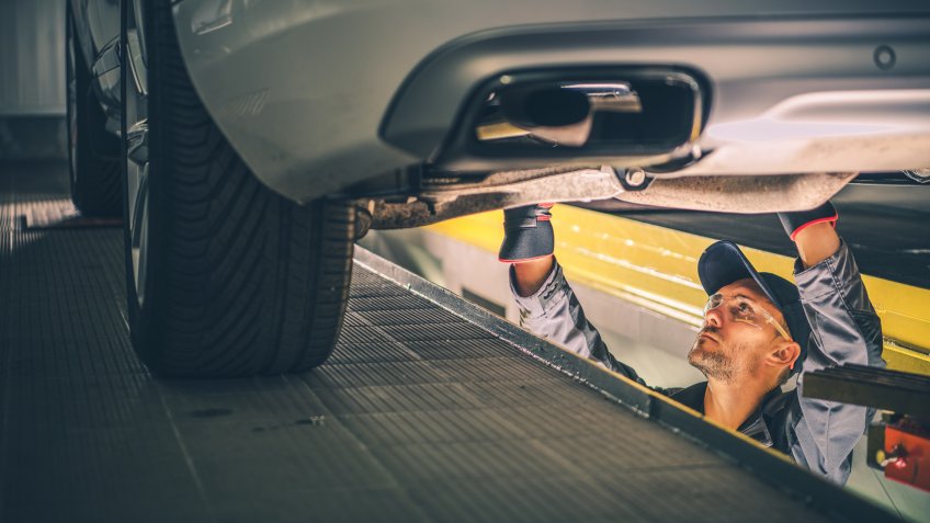 Car Diagnostic Technician Under the Vehicle.