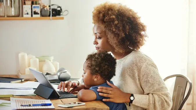 Boy looking at mother using digital tablet.