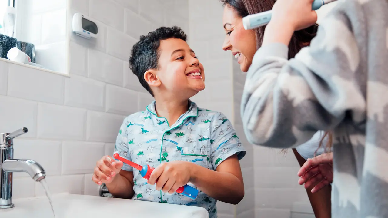 Children are brushing their teeth in the bathroom at home.