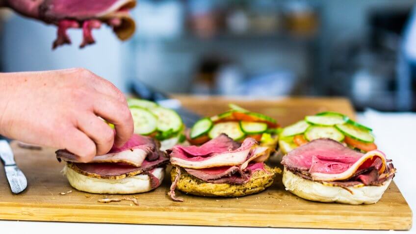 person making sandwiches to bring to baseball game
