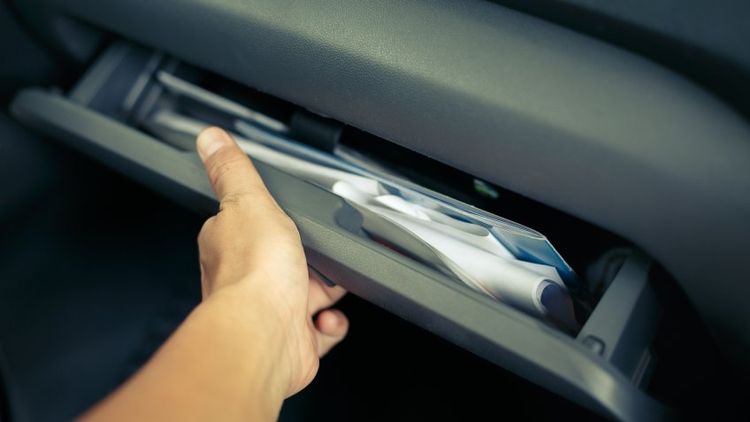 person opening up car glove compartment