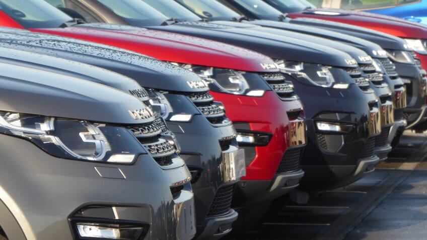 row of new cars in dealership lot