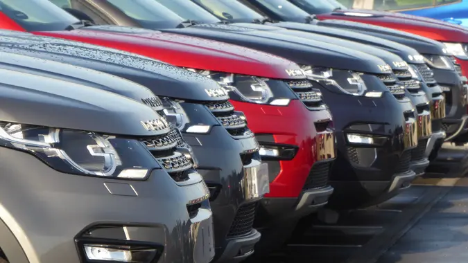 row of new cars in dealership lot