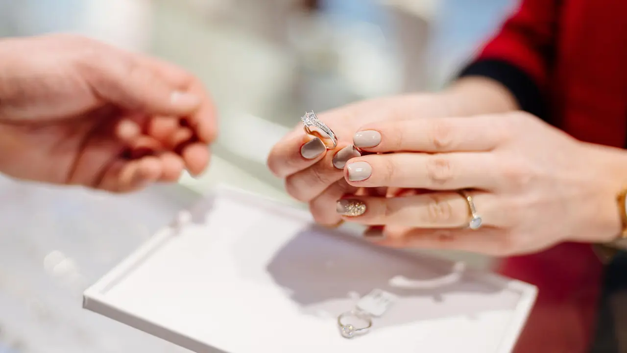 Female seller in a luxury jewelry store presents a ring.