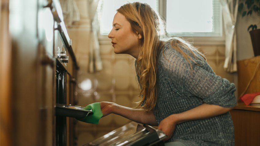 Young woman baking pastries in the kitchen at home.