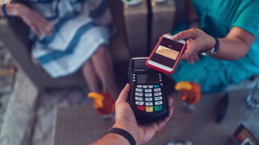 Young women in the bar paying contactless ++++ Note for the inspector: Credit card is fake and made especially for the photosession ++++.