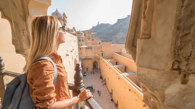 Young woman traveling in India contemplating ancient temple in Jaipur, India.