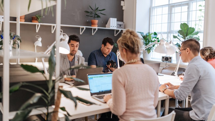 Coworkers working in modern co-working space in Scandinavia.