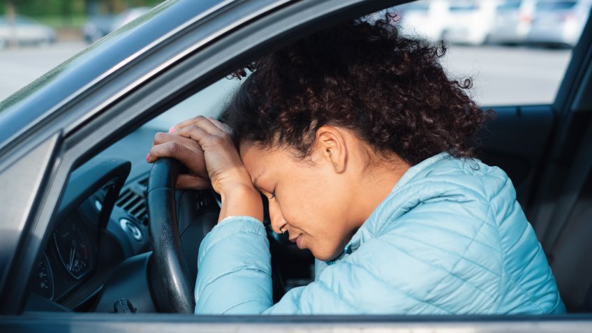 Frustrated woman stuck in traffic jam.