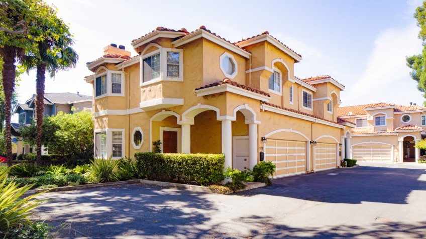 Luxury Spanish styled two storied house and driveway panorama in San Jose California with nicely landscaped greenery, photographed from the street.