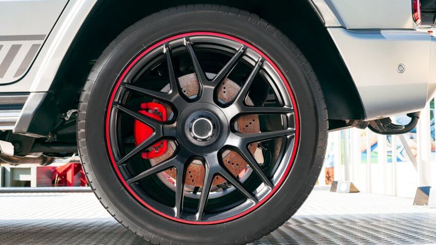 Side view of modern car with rubber tire on wheel rim.