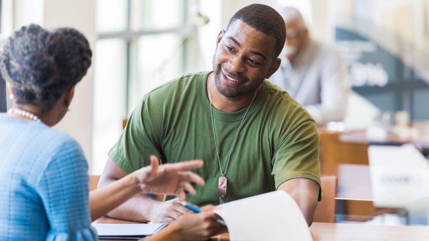 A mid adult soldier is happy to hear he qualifies for a good interest rate on his certificate of deposit.