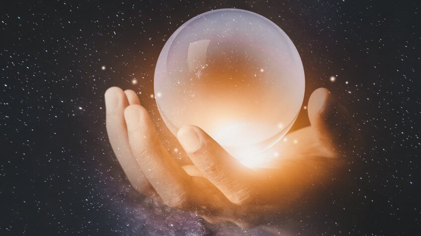 businessman hand holding crystal clear ball with galaxy universe space background.
