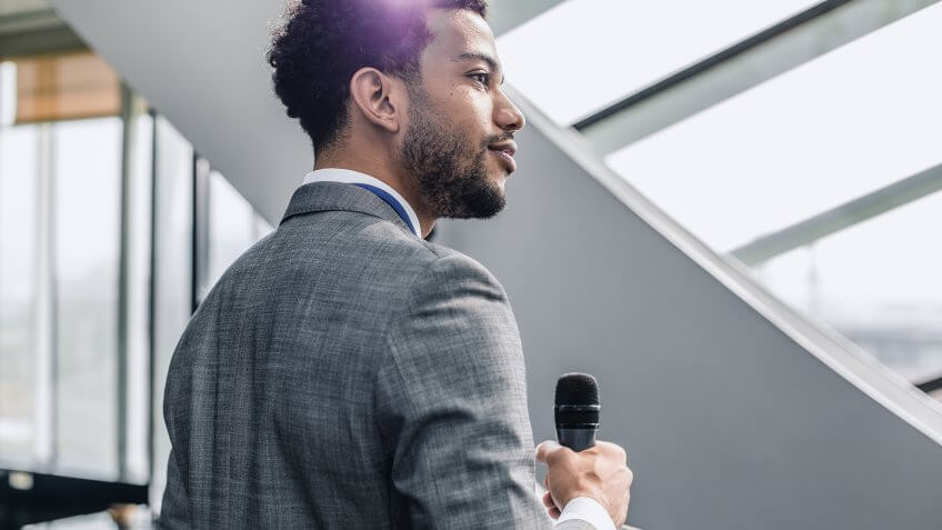 businessman leader with microphone giving speech